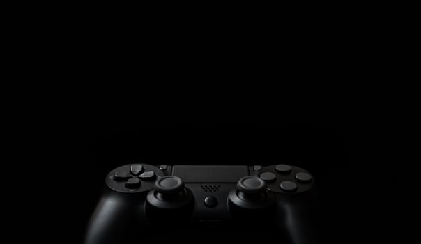 Modern black gamepad on a dark background. Game concept with copy space for text or design. photo