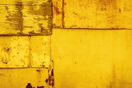 Yellow textural background of old rusty metal sheets fastened together with rivets and nails. photo