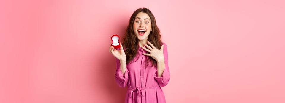 Excited young woman showing engagement ring, getting married, smiling happy, talking about wedding day, receive marriage proposal. Copy space photo