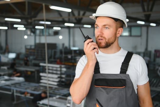 A young male engineer inspects the production of plastic window frames photo
