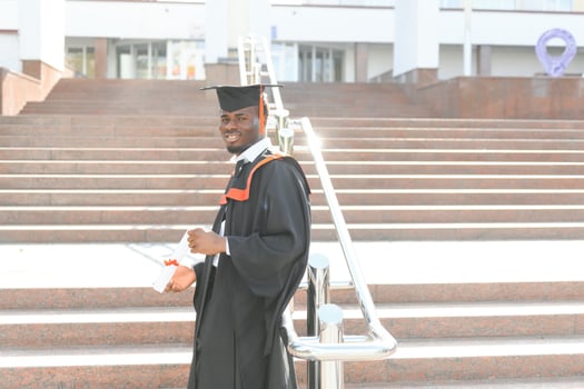 smiling african american graduated student showing diploma photo