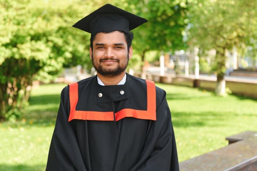 Portrait of happy man, graduation or student in university campus photo
