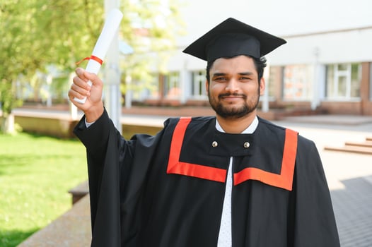 Portrait of happy man, graduation or student in university campus photo
