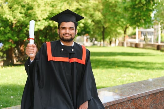 Portrait of happy man, graduation or student in university campus photo