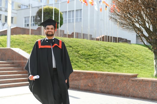 Handsome indian graduate in graduation glow with diploma photo