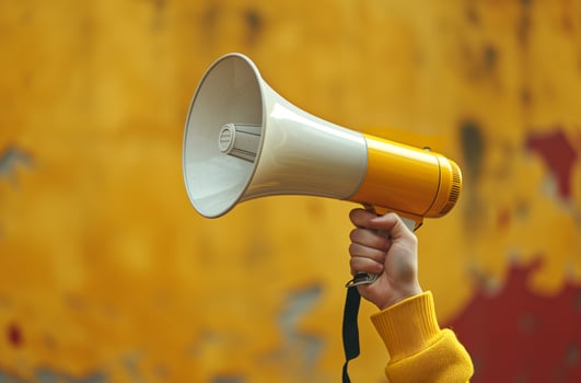 Hand holding yellow megaphone photo