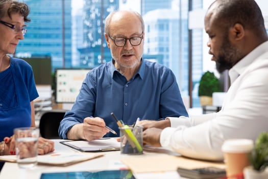 Mature person signing a contract with insurance agency banker, agreeing to the new pension plan contract with expert. Retired man collaborating with advisor to secure his life savings. photo