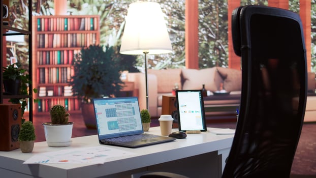 Empty home office belonging to a small business owner with data sales reports on laptop, annual information and invoices for accounting work. Finance and economy budget balance. photo