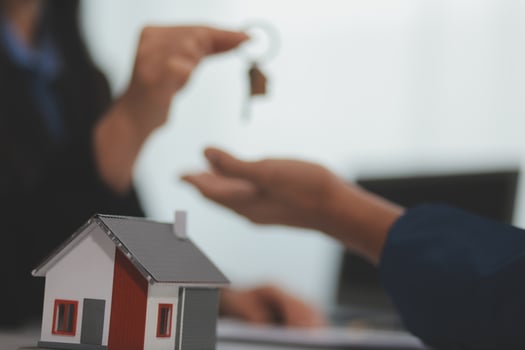 Estate agent giving house keys to client after signing agreement contract real estate with approved mortgage application form, concerning mortgage loan offer for and house insurance. photo