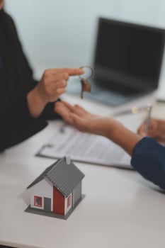 Estate agent giving house keys to client after signing agreement contract real estate with approved mortgage application form, concerning mortgage loan offer for and house insurance. photo