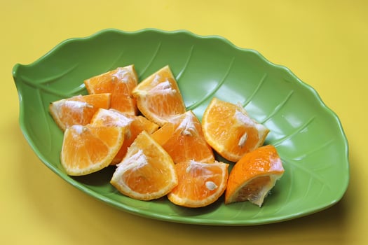 Sliced juicy orange fruit on yellow photo