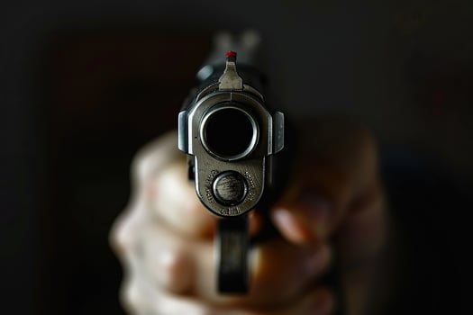 Man aims through the sight of combat metal pistol to hit the target photo