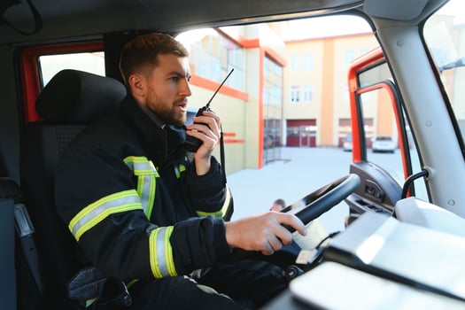 Firefighter using radio set while driving fire truck photo