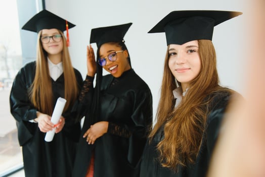 Pretty female college graduate at graduation with classmates photo