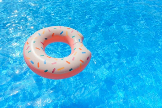 Inflatable swim ring in shape of donut floating in pool photo