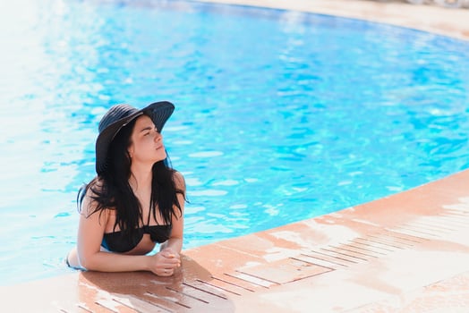 At pool beach. People woman lifestyle relax and rest near luxury swimming pools sunbath at home, summer day at the resort in the hotel. Summer Concept. photo