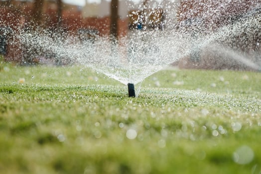 Modern device of irrigation garden. Irrigation system - technique of watering in the garden. Lawn sprinkler spraying water over green grass. photo