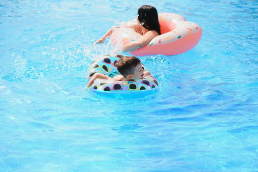 Mother and baby in outdoor swimming pool of tropical resort. Kid learning to swim. Mom and child playing in water. Family summer vacation in exotic destination. Active and healthy sport for kids. photo