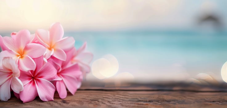 Pink Flowers Resting on Weathered Wood by the Ocean at Sunset photo