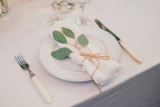 Table setting with napkin on empty white plate, wineglasses and cutlery on table, copy space. Place setting at wedding reception. Table served for banquet photo