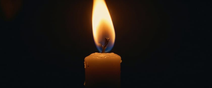 The solitary flame of a candle pierces the darkness. photo