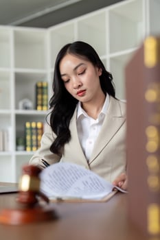 Professional Female Lawyer Working in Modern Office with Legal Documents and Gavel on Desk photo