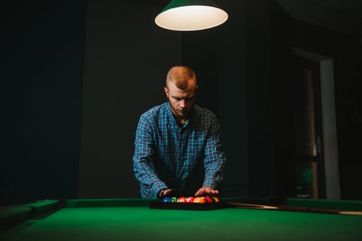 Young handsome man leaning over the table while playing snooker photo