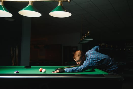 Young man playing billiards in the dark billiard club photo