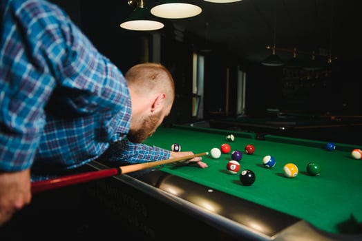 Young man playing billiards in the dark billiard club photo