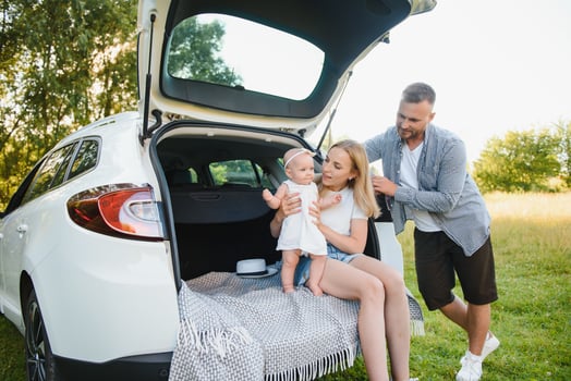 Family with kid sitting in car trunk photo