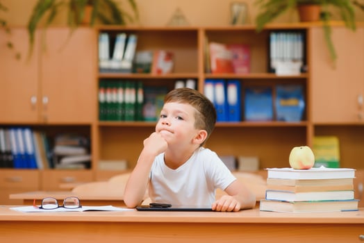 Happy schoolboys sitting at desk, classroom photo