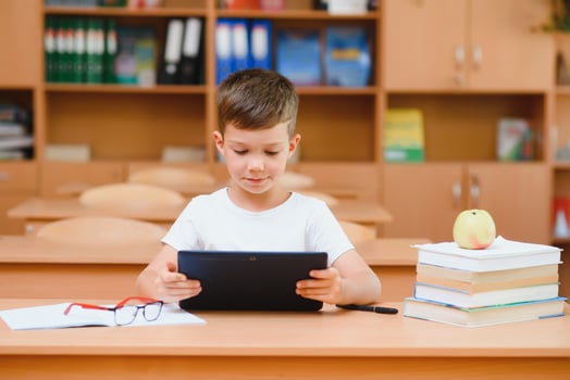 school boy using tablet compute in classroom photo