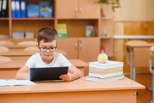 school boy using tablet compute in classroom photo