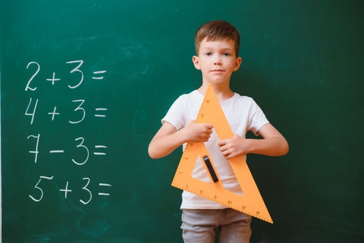 Funny schoolboy near the green school board in the classroom. Elementary school. Back to school. photo