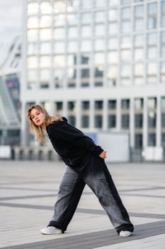 Young Woman Dancing Urban Style in Front of Modern Glass Building During Daytime photo