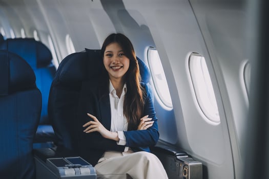 Young Asian female tourist traveling alone on a plane is drinking hot coffee and looking out the window. photo