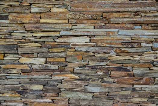 Stone wall made of multi-colored layered natural sandstone photo