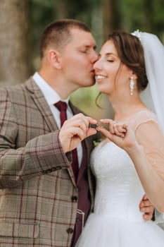 A man and woman are kissing and holding a key in their hands. The man is wearing a suit and tie, and the woman is wearing a wedding dress. Concept of love and commitment between the couple photo