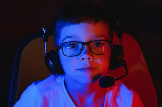 Little boy playing game in the dark room photo
