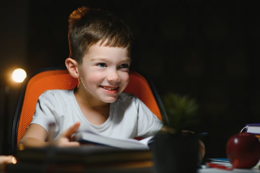 boy doing homework at home in evening photo