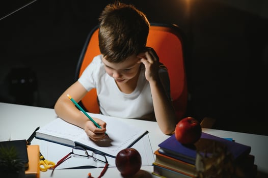Little boy painting in a dark room late in the evening photo