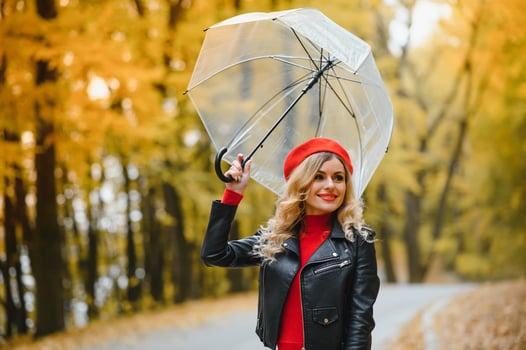 a girl walks in the autumn park under an umbrella photo