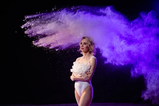 Woman posing with purple particles sprayed in air photo