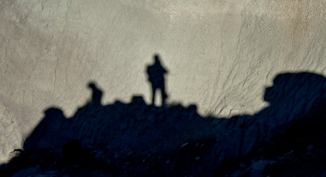 Shadow of a man against a background of dry cracked clay, cracks on the ground. photo