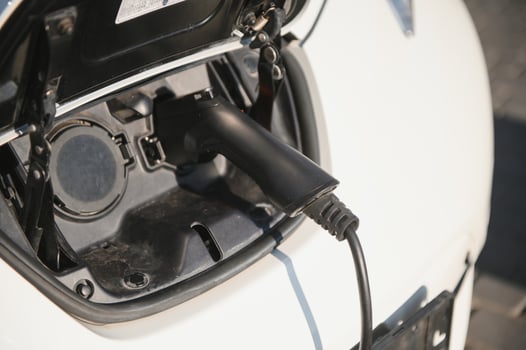 Charging modern electric car battery on the street which are the future of the Automobile, Close up of power supply plugged into an electric car being charged for hybrid . New era of vehicle fuel. photo