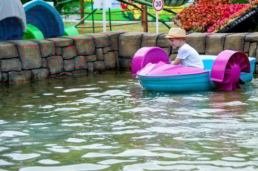 Kid playing rowing water paddle boat. Soft focus. . High quality photo