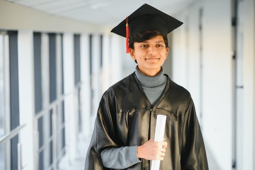 Portrait of indian handsome male graduate in graduation robe and blured background. photo