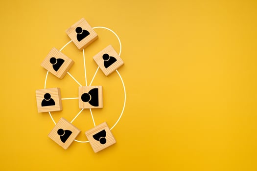 Top view of wooden blocks with black human icons scattered on a yellow background. photo