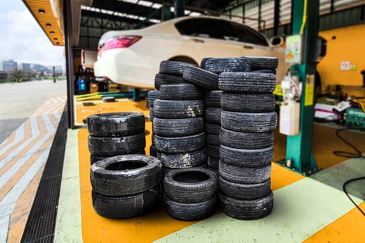 Pile of old car tires in a car repair shop , Old car tire waste , Car maintenance concept photo