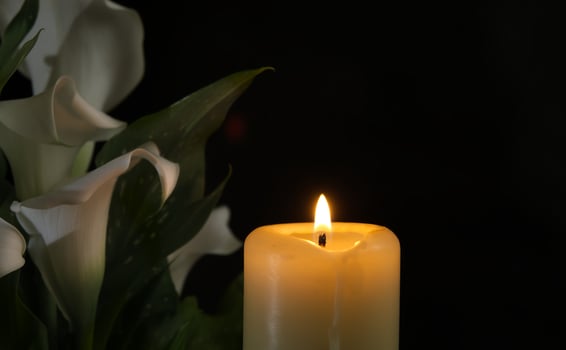 Burning wax candle in close up and white calla lily photo